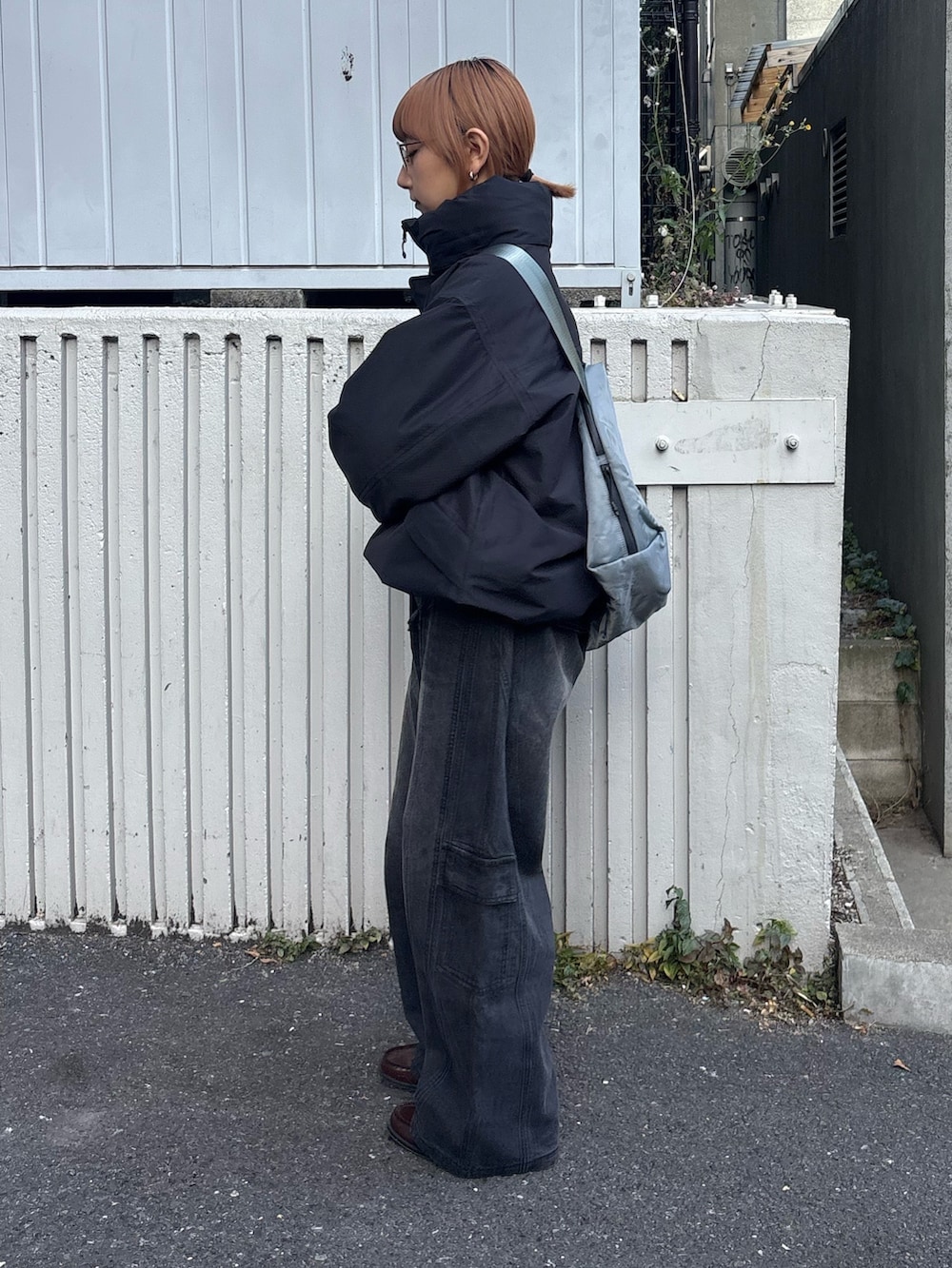 ブラック系のデニムパンツ、グレー系のショルダーバッグ、ブラック系のダウンジャケット/コートを着用したレディースの冬コーディネートの2枚目の写真