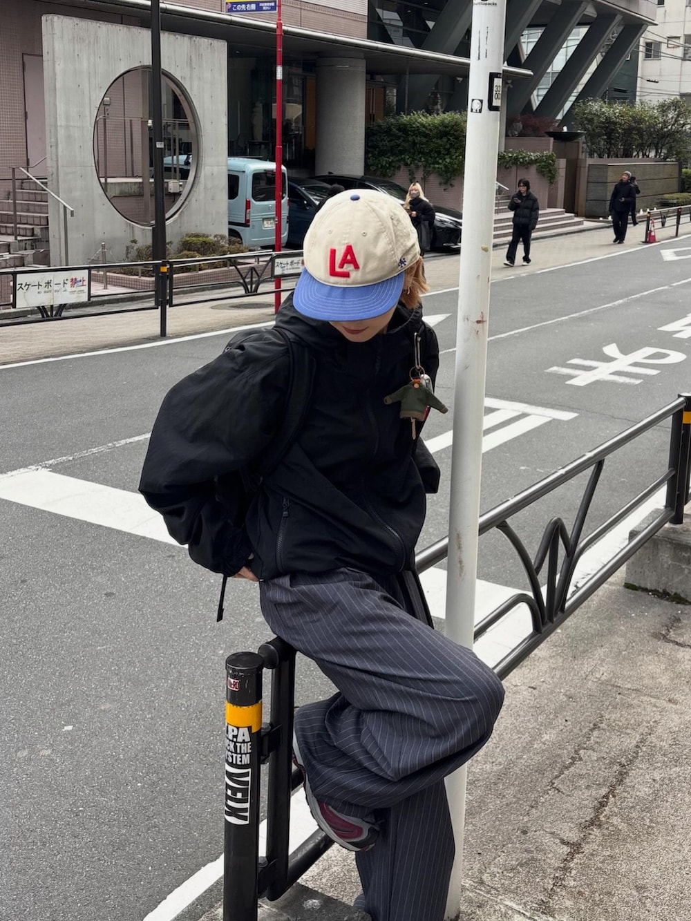 ブラック系のマウンテンパーカー、グレー系のスラックスを着用したレディースの春コーディネートの2枚目の写真