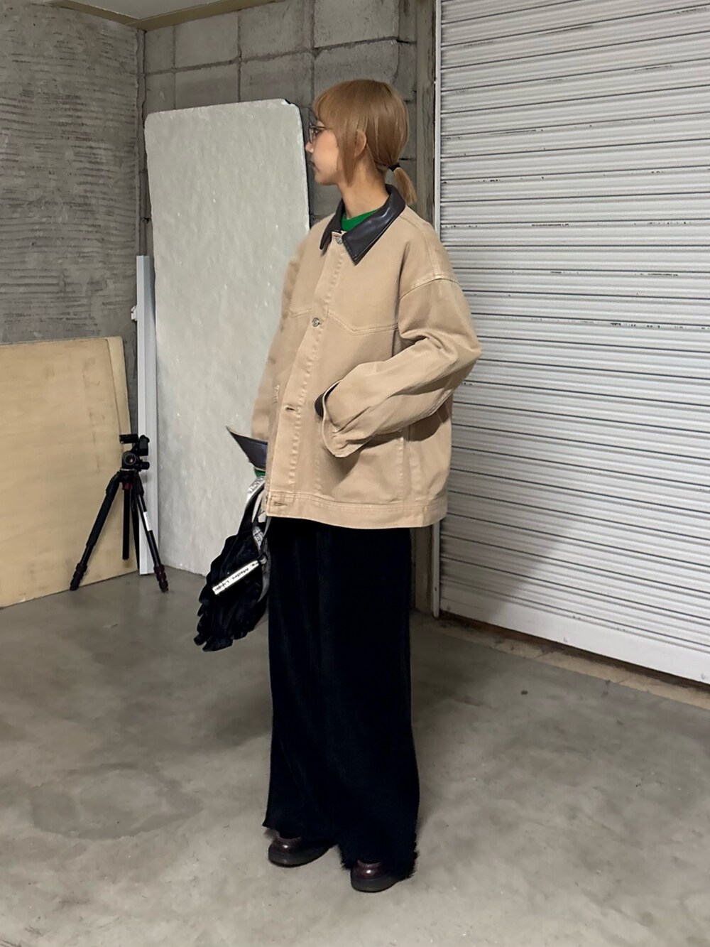 グリーン系のニット/セーター、ベージュ系のデニムジャケット、ブラック系のトートバッグを着用したレディースの冬コーディネートの2枚目の写真