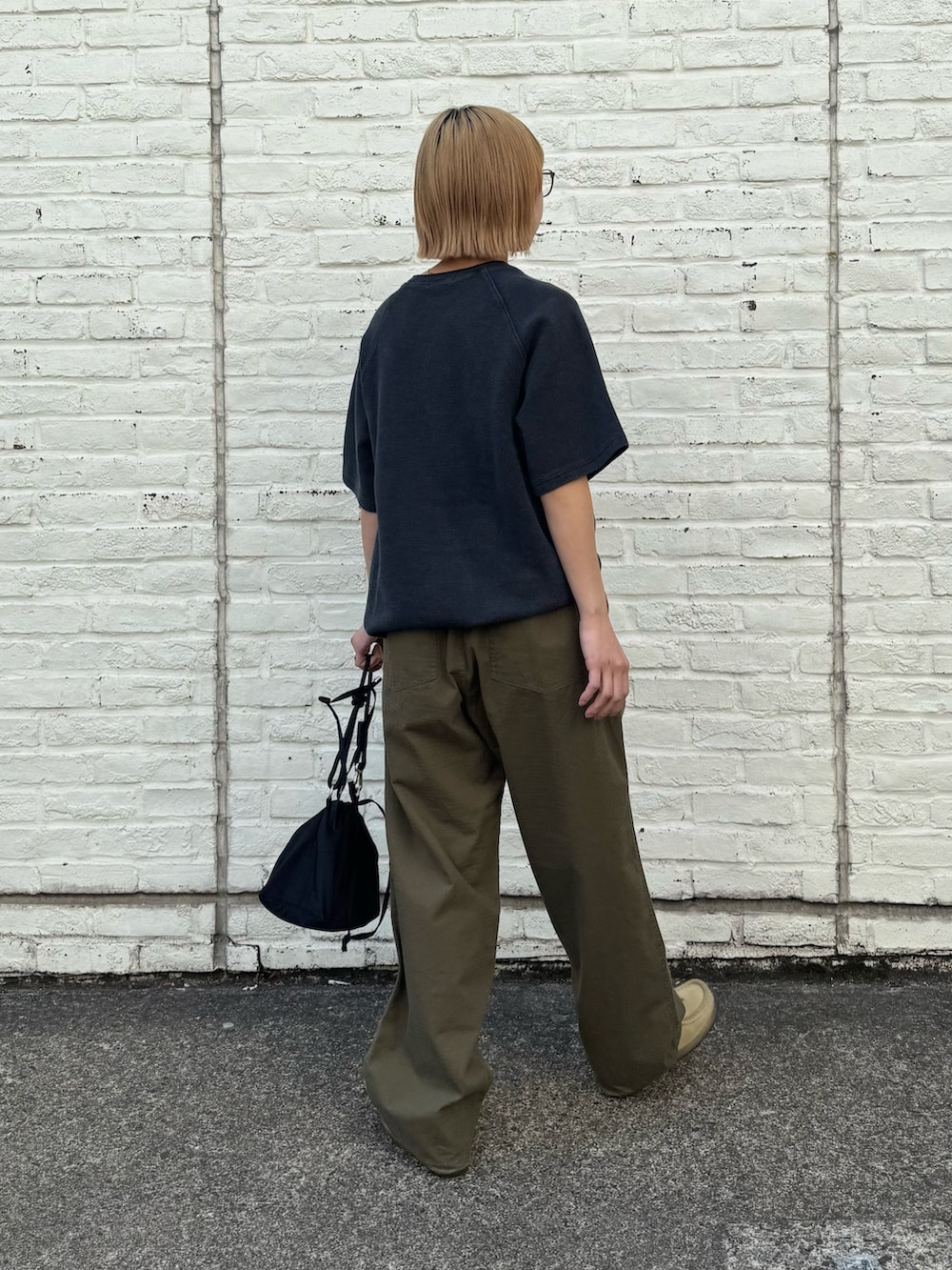 ブラック系のTシャツ/カットソー、ブラック系のショルダーバッグ、グリーン系のカーゴパンツを着用したレディースの春コーディネートの2枚目の写真