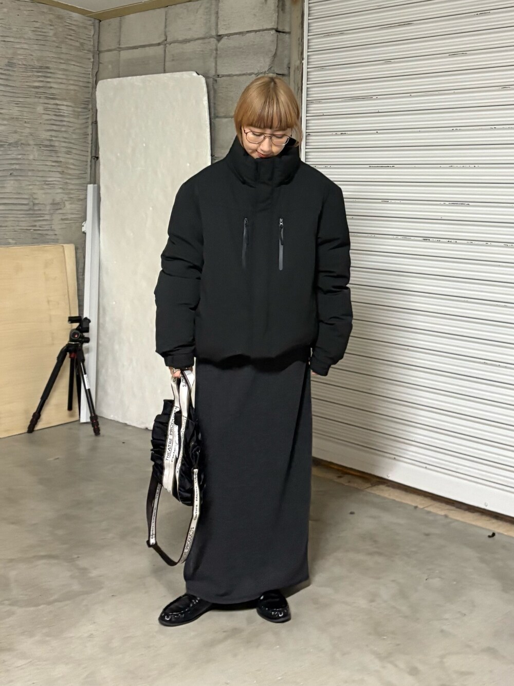 ブラック系のトートバッグ、グレー系のワンピース、ブラック系のダウンジャケット/コートを着用したレディースの冬コーディネートの2枚目の写真