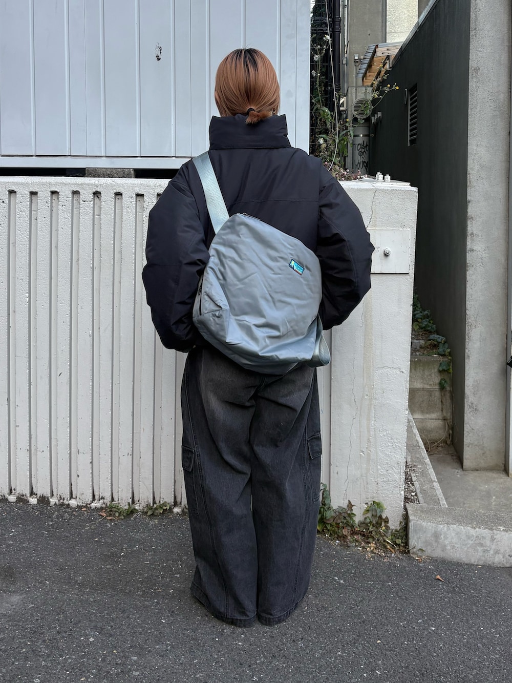 ブラック系のデニムパンツ、グレー系のショルダーバッグ、ブラック系のダウンジャケット/コートを着用したレディースの冬コーディネートの3枚目の写真