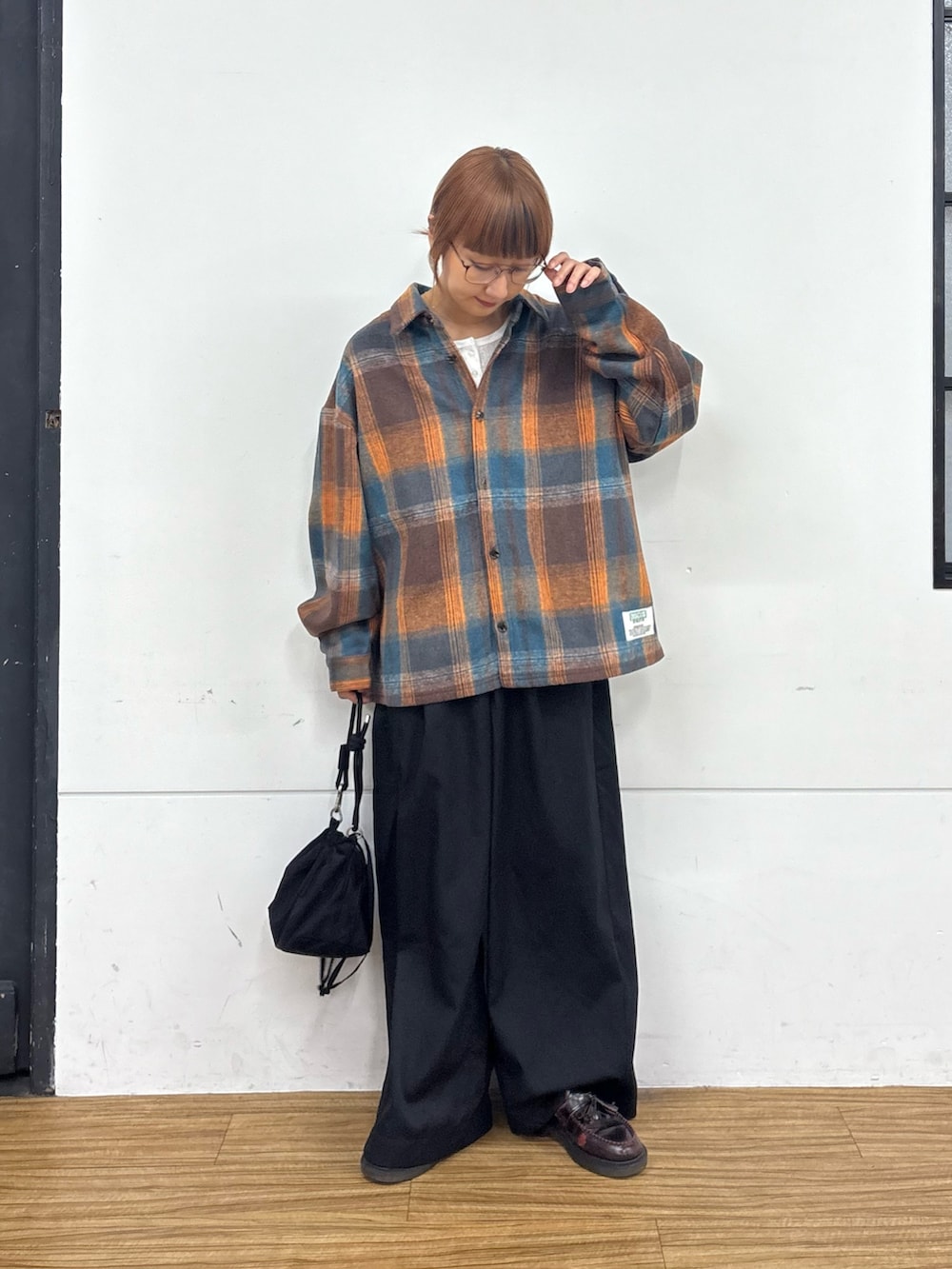 ホワイト系のTシャツ/カットソー、オレンジ系のシャツ/ブラウス、ブラック系のショルダーバッグを着用したレディースの秋コーディネートの2枚目の写真