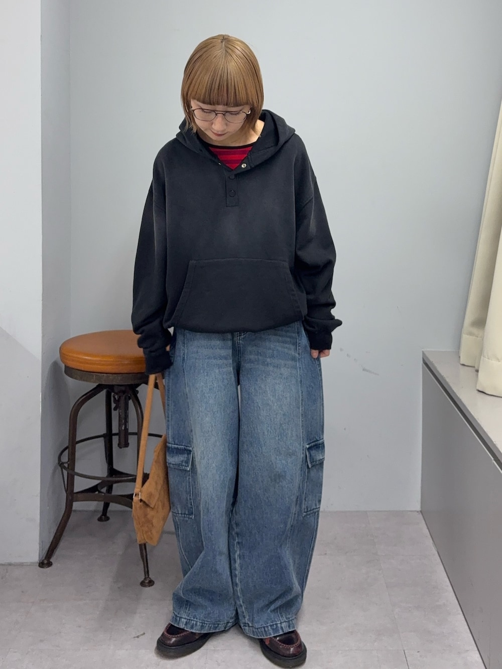 ブルー系のカーゴパンツ、イエロー系のハンドバッグ、ブラック系のパーカーを着用したレディースの冬コーディネートの2枚目の写真