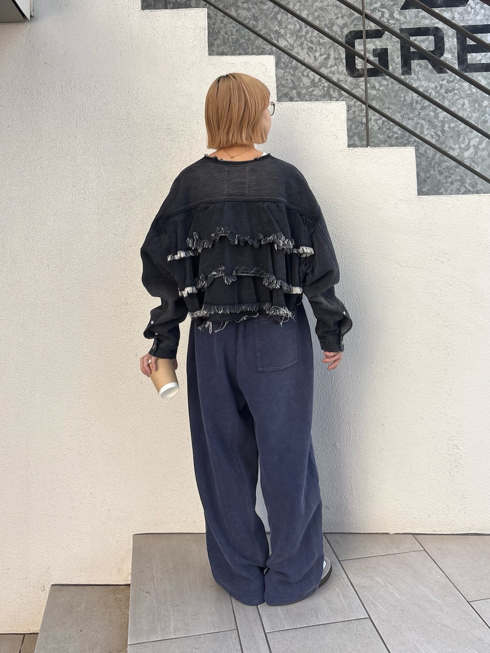 ブラック系のデニムジャケット、ホワイト系のTシャツ/カットソー、ブルー系のスウェットパンツを着用したレディースの春コーディネートの4枚目の写真