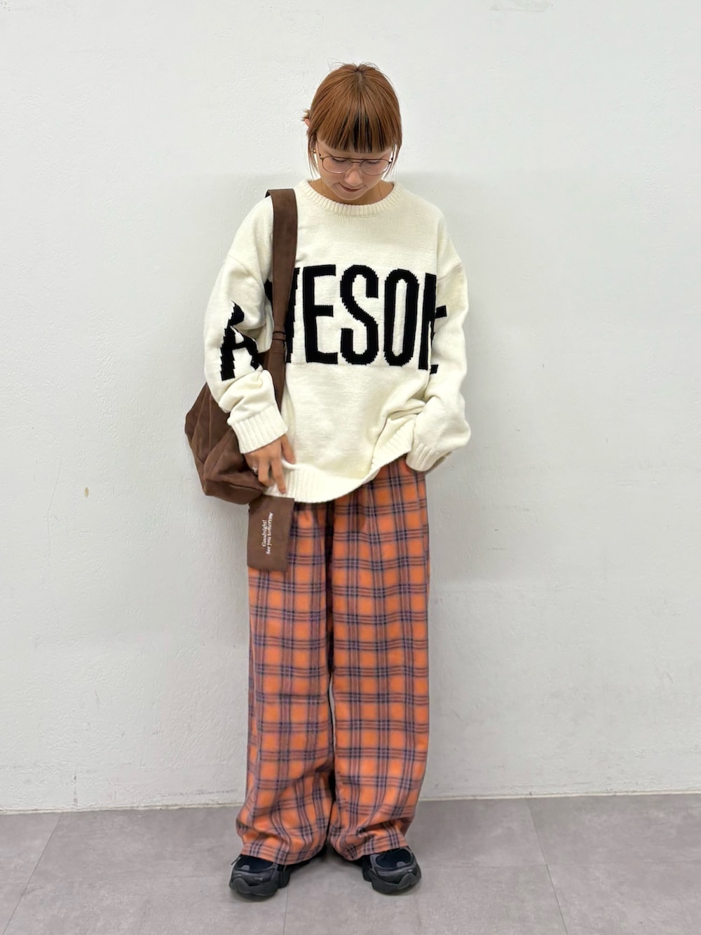 ホワイト系のニット/セーター、ブラウン系のトートバッグ、オレンジ系のその他パンツを着用したレディースの秋コーディネートの2枚目の写真