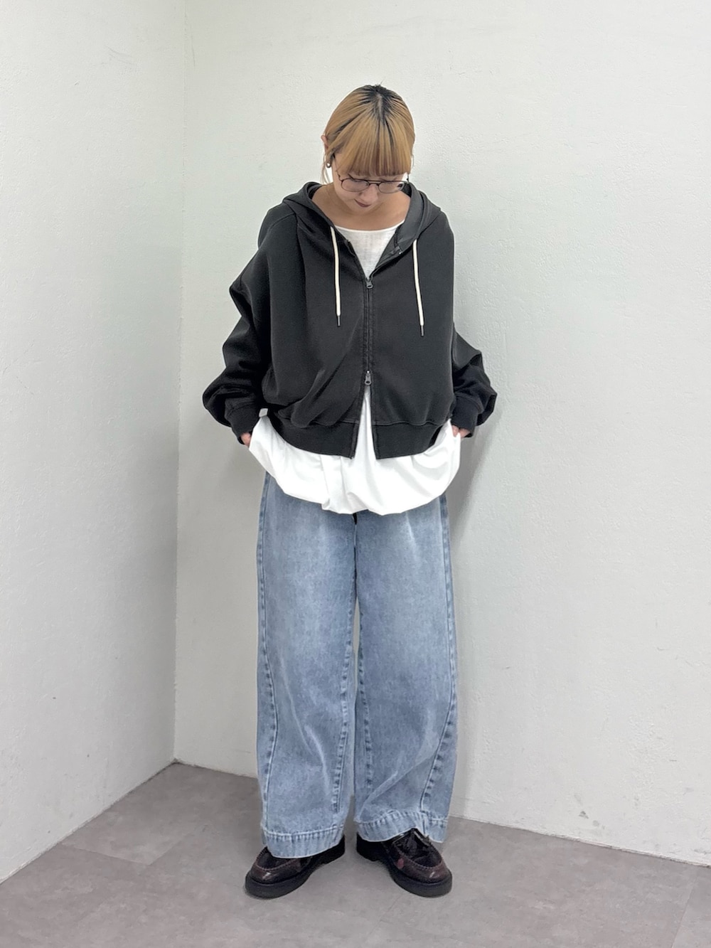 グレー系のパーカー、ホワイト系のTシャツ/カットソー、ブルー系のデニムパンツを着用したレディースの春コーディネートの2枚目の写真