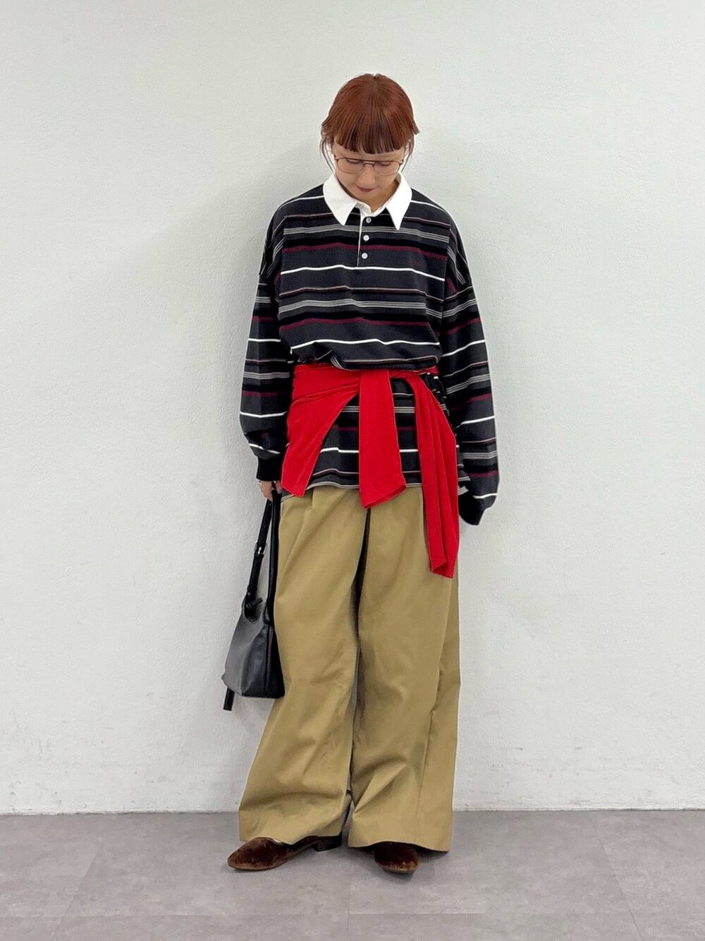 グレー系のTシャツ/カットソー、レッド系のTシャツ/カットソー、ベージュ系のデニムパンツを着用したレディースの秋コーディネートの2枚目の写真