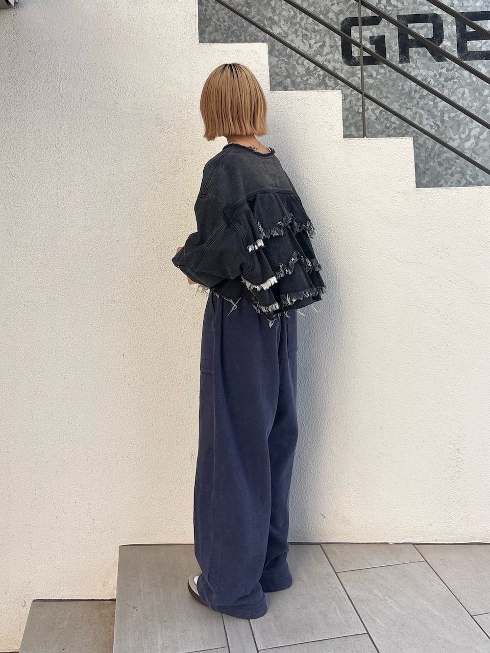 ブラック系のデニムジャケット、ホワイト系のTシャツ/カットソー、ブルー系のスウェットパンツを着用したレディースの春コーディネートの3枚目の写真