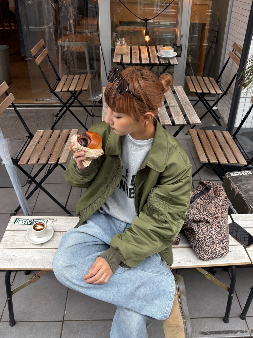 グレー系のスウェット、ブルー系のデニムパンツ、グリーン系のMA-1を着用したレディースの秋コーディネートの3枚目の写真