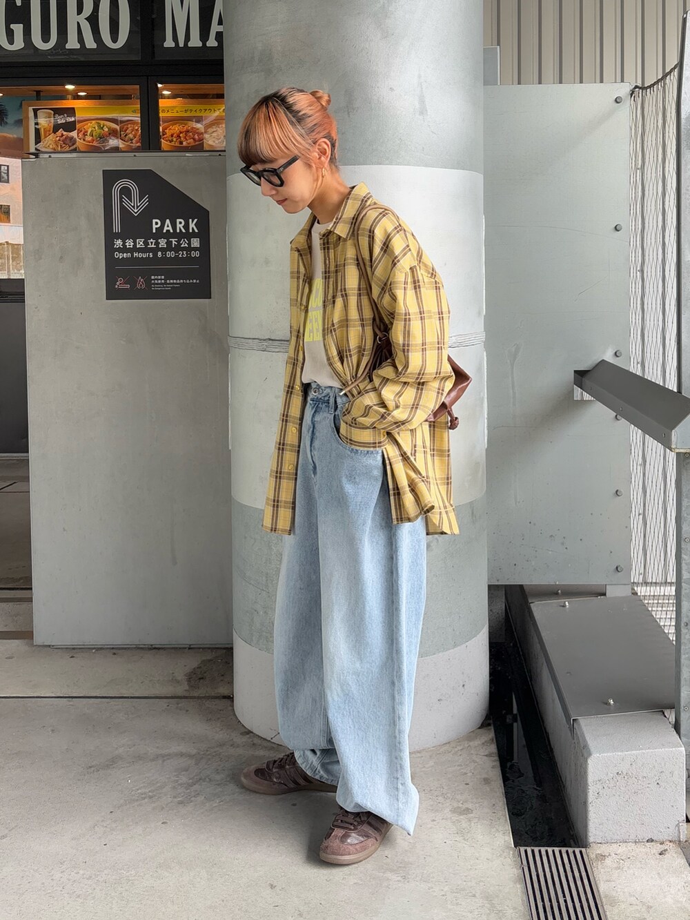 イエロー系のシャツ/ブラウス、グレー系のTシャツ/カットソー、ブルー系のデニムパンツを着用したレディースの秋コーディネートの2枚目の写真
