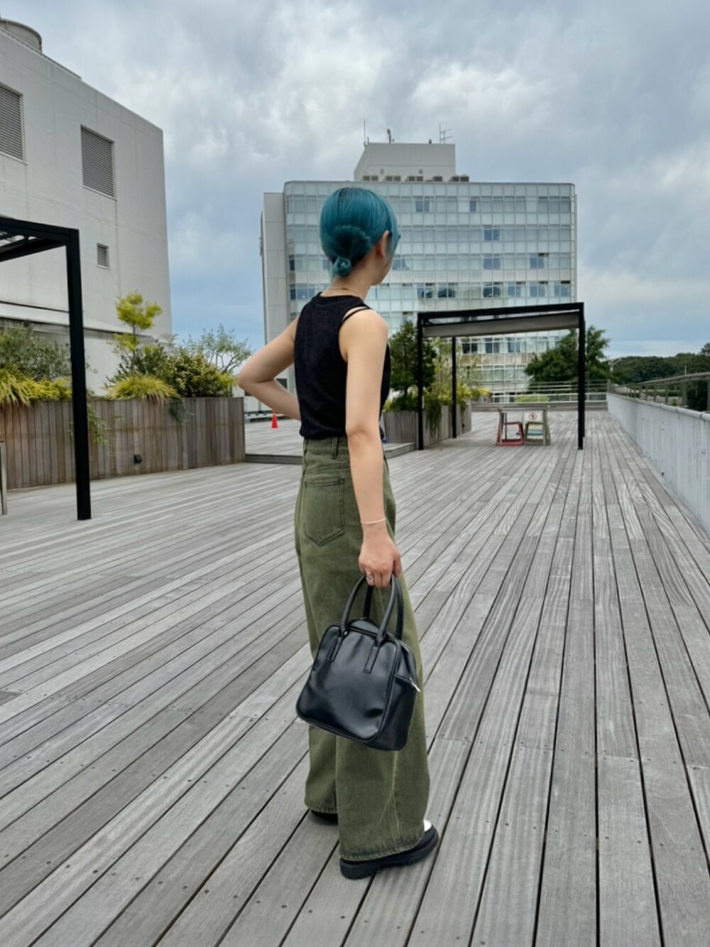 ホワイト系のローファー、ブラック系のボストンバッグ、ブラウン系のデニムパンツを着用したレディースの夏コーディネートの2枚目の写真