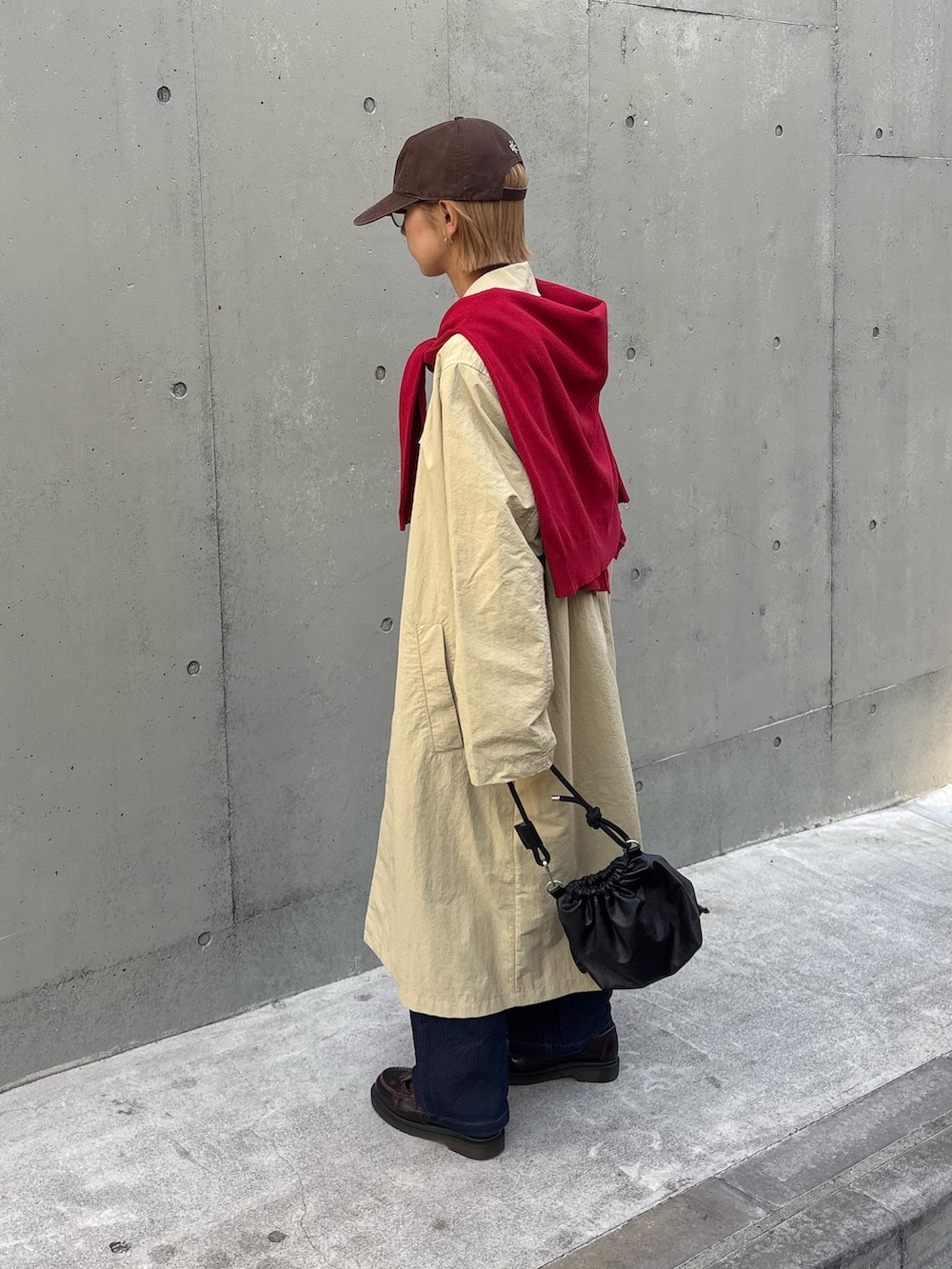 レッド系のニット/セーター、ブルー系のシャツ/ブラウス、ベージュ系のステンカラーコートを着用したレディースの冬コーディネートの3枚目の写真