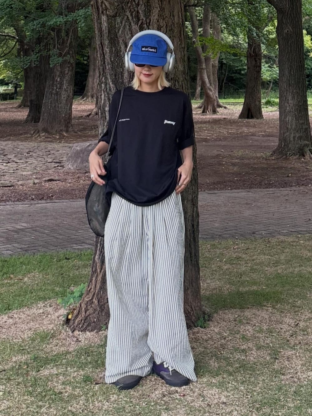 ブラック系のTシャツ/カットソー、ブラック系のトートバッグ、ホワイト系のその他パンツを着用したレディースの夏コーディネートの2枚目の写真