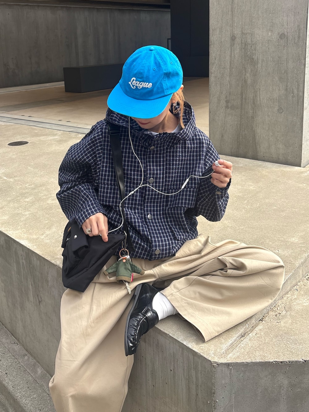 ブルー系のパーカー、ベージュ系のその他パンツ、ブラック系のショルダーバッグを着用したレディースの春コーディネートの2枚目の写真