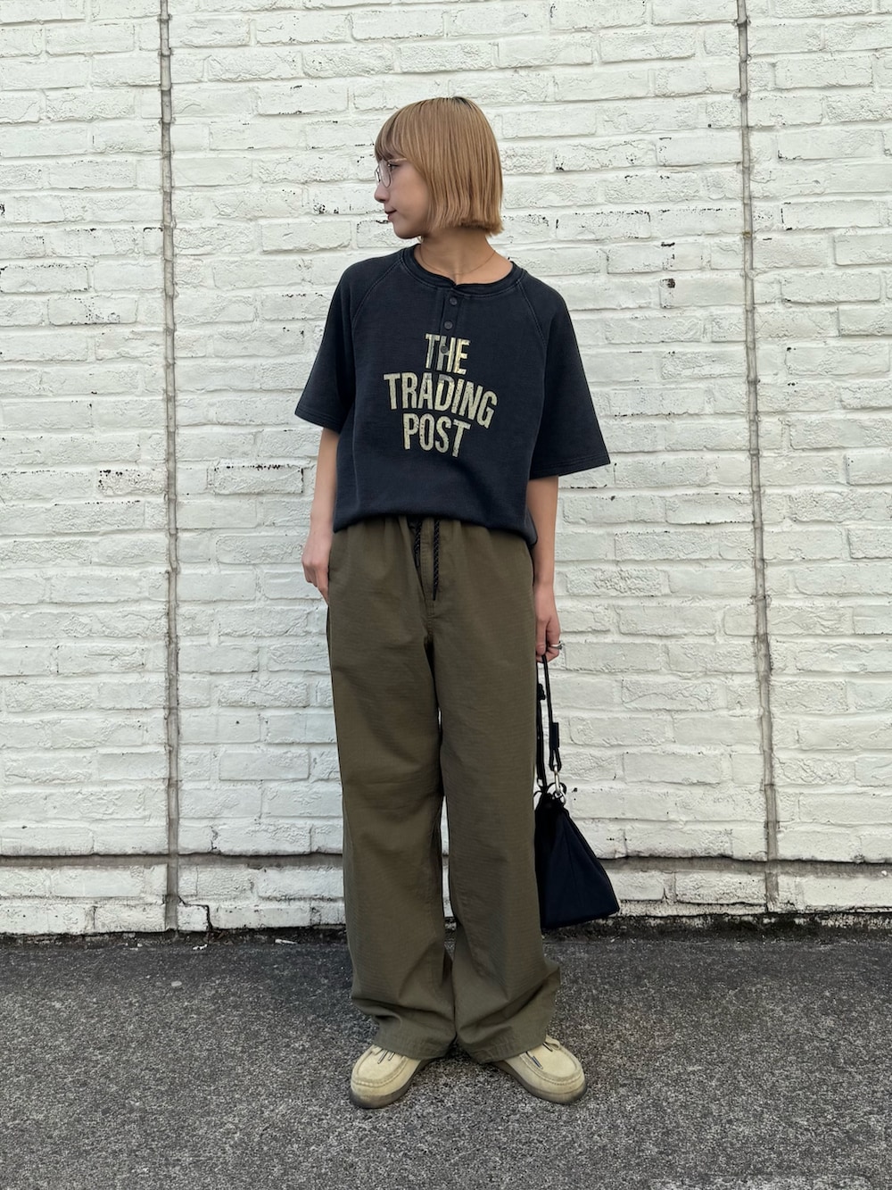 ブラック系のTシャツ/カットソー、ブラック系のショルダーバッグ、グリーン系のカーゴパンツを着用したレディースの春コーディネートの3枚目の写真