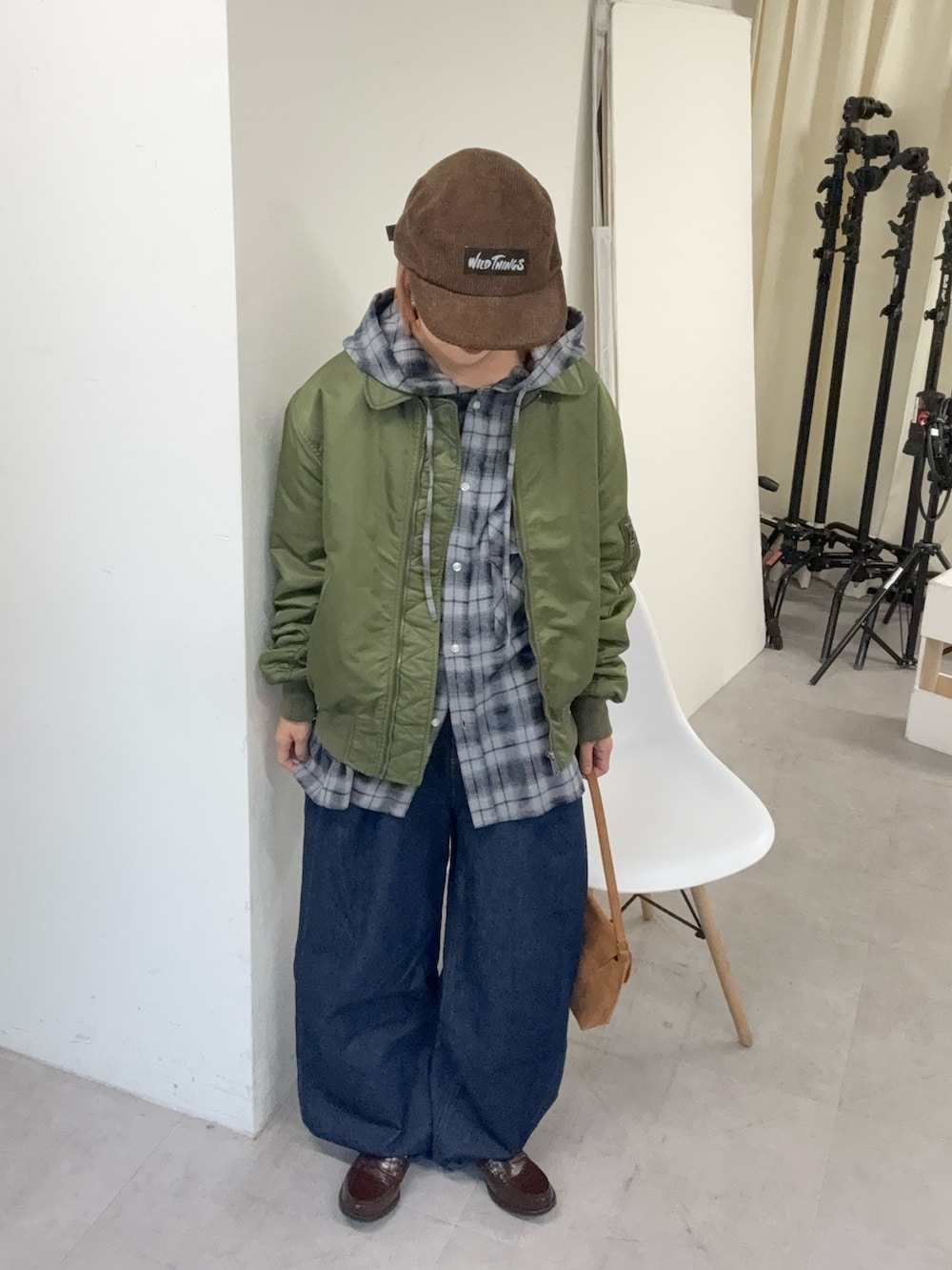 グリーン系のMA-1、グレー系のシャツ/ブラウス、ブルー系のデニムパンツを着用したレディースの冬コーディネートの2枚目の写真