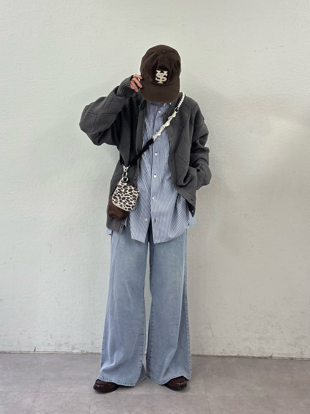 ブルー系のデニムパンツ、ブルー系のシャツ/ブラウス、ブラウン系のショルダーバッグを着用したレディースの春コーディネートの2枚目の写真