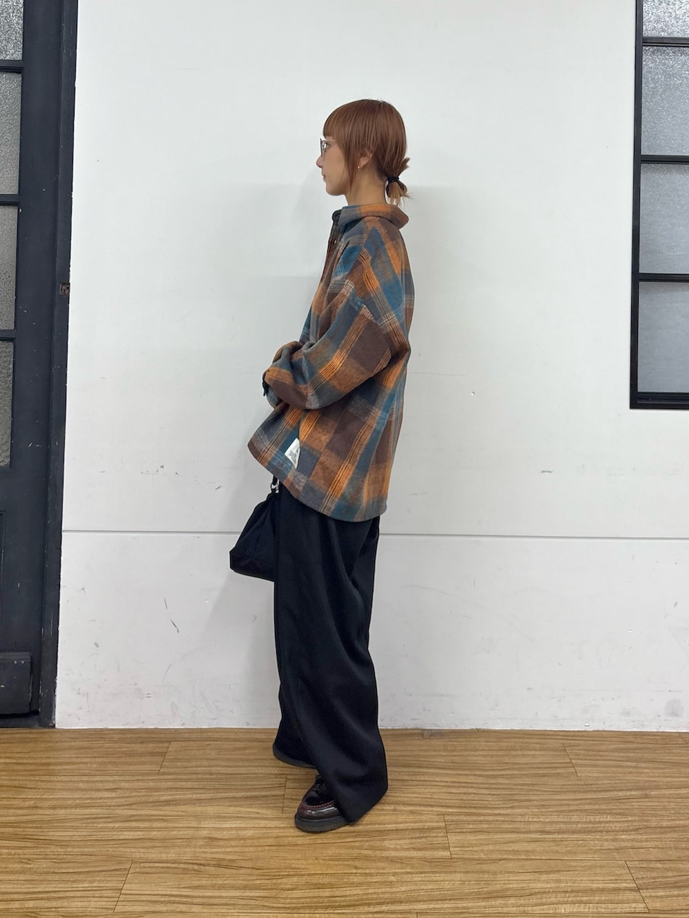 ホワイト系のTシャツ/カットソー、オレンジ系のシャツ/ブラウス、ブラック系のショルダーバッグを着用したレディースの秋コーディネートの3枚目の写真