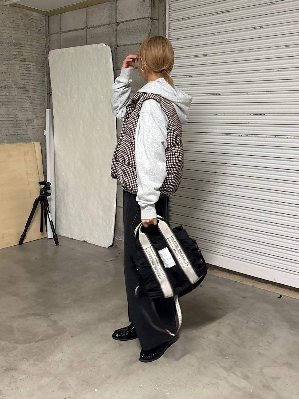 グレー系のワンピース、ブラウン系のベスト、グレー系のパーカーを着用したレディースの冬コーディネートの2枚目の写真