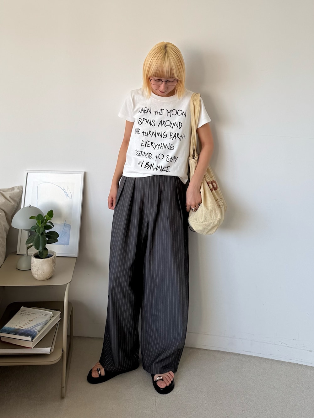 ホワイト系のTシャツ/カットソー、グレー系のスラックス、ベージュ系のトートバッグを着用したレディースの夏コーディネートの2枚目の写真