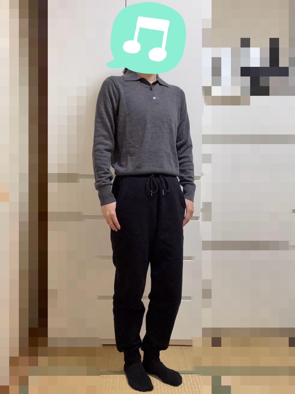 グレー系のニット/セーター、ホワイト系のダウンジャケット/コート、ブラック系のスウェットパンツを着用したレディースの冬コーディネートの2枚目の写真