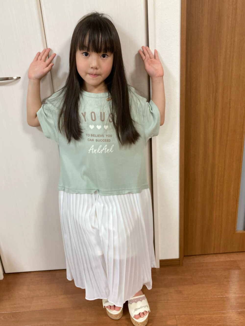 グリーン系のワンピースを着用したキッズの春コーディネートの2枚目の写真