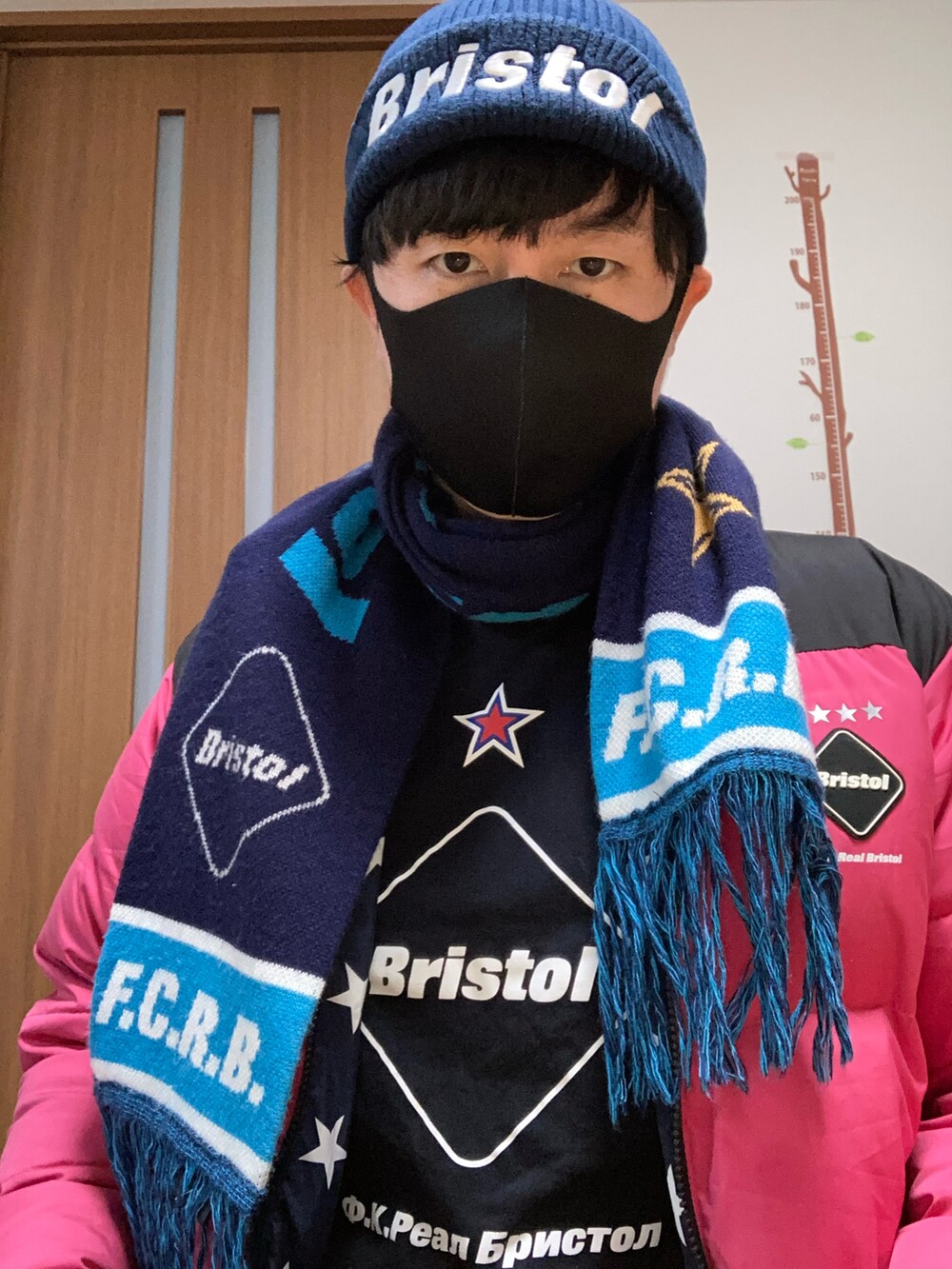 ブラック系のTシャツ/カットソー、ピンク系のダウンジャケット/コート、ブラック系のマフラーを着用したメンズの冬コーディネートの2枚目の写真