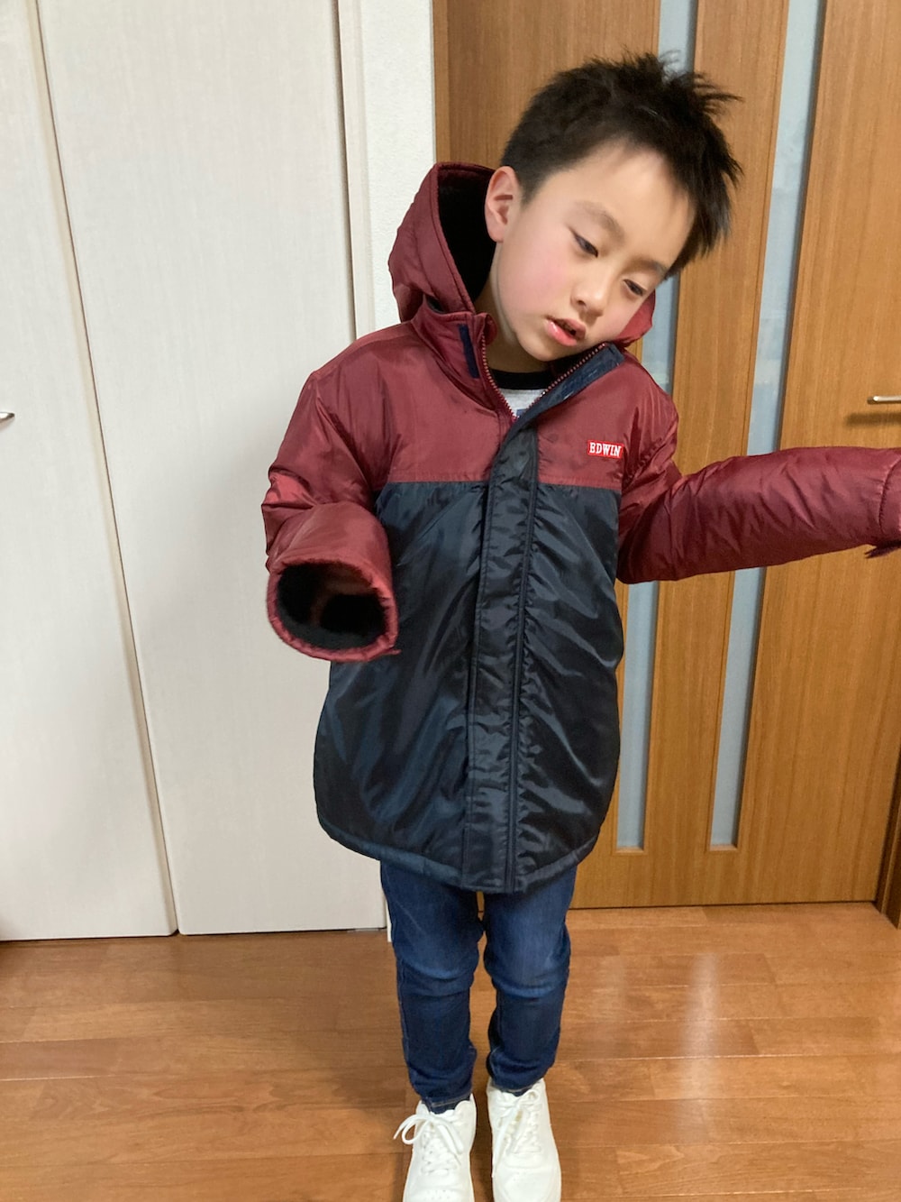 ブラウン系のダウンジャケット/コート、ブルー系のデニムパンツ、その他のその他を着用したキッズの秋コーディネートの2枚目の写真