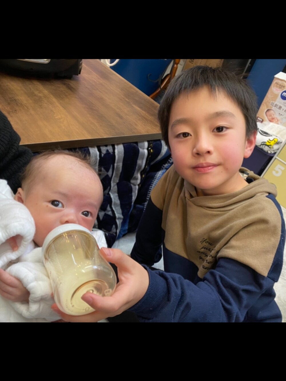 ブラウン系のスウェットを着用したキッズの冬コーディネートの2枚目の写真