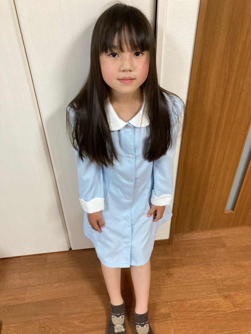 ブルー系のワンピースを着用したキッズの春コーディネートの2枚目の写真