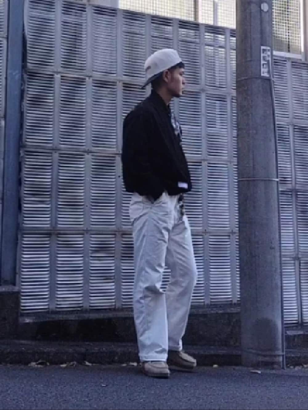 ホワイト系のデニムパンツ、ブラック系のスカジャン、ホワイト系のキャップを着用したメンズの秋コーディネートの2枚目の写真
