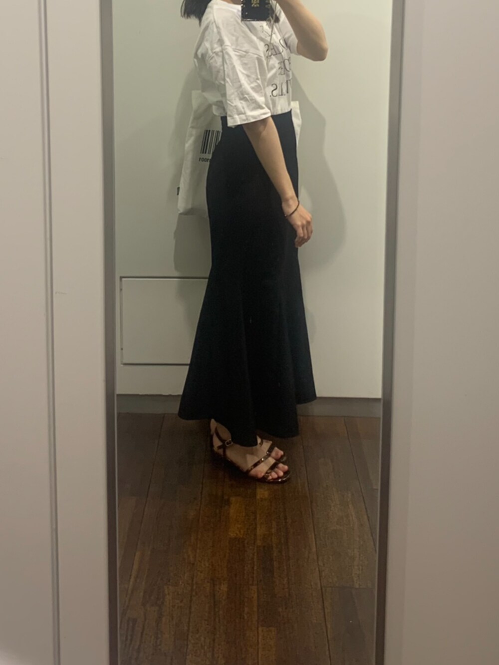 ホワイト系のTシャツ/カットソー、ブラック系のスカート、ブラウン系のサンダルを着用したレディースの夏コーディネートの2枚目の写真