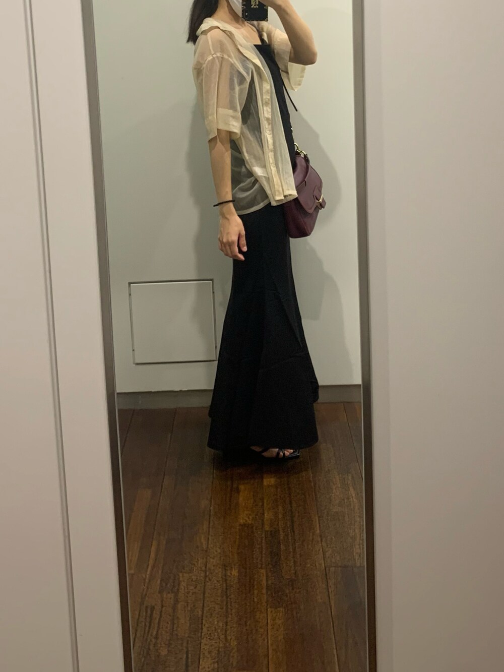 パープル系のショルダーバッグ、ブラック系のオールインワン・サロペット、ベージュ系のトップスを着用したレディースの夏コーディネートの2枚目の写真