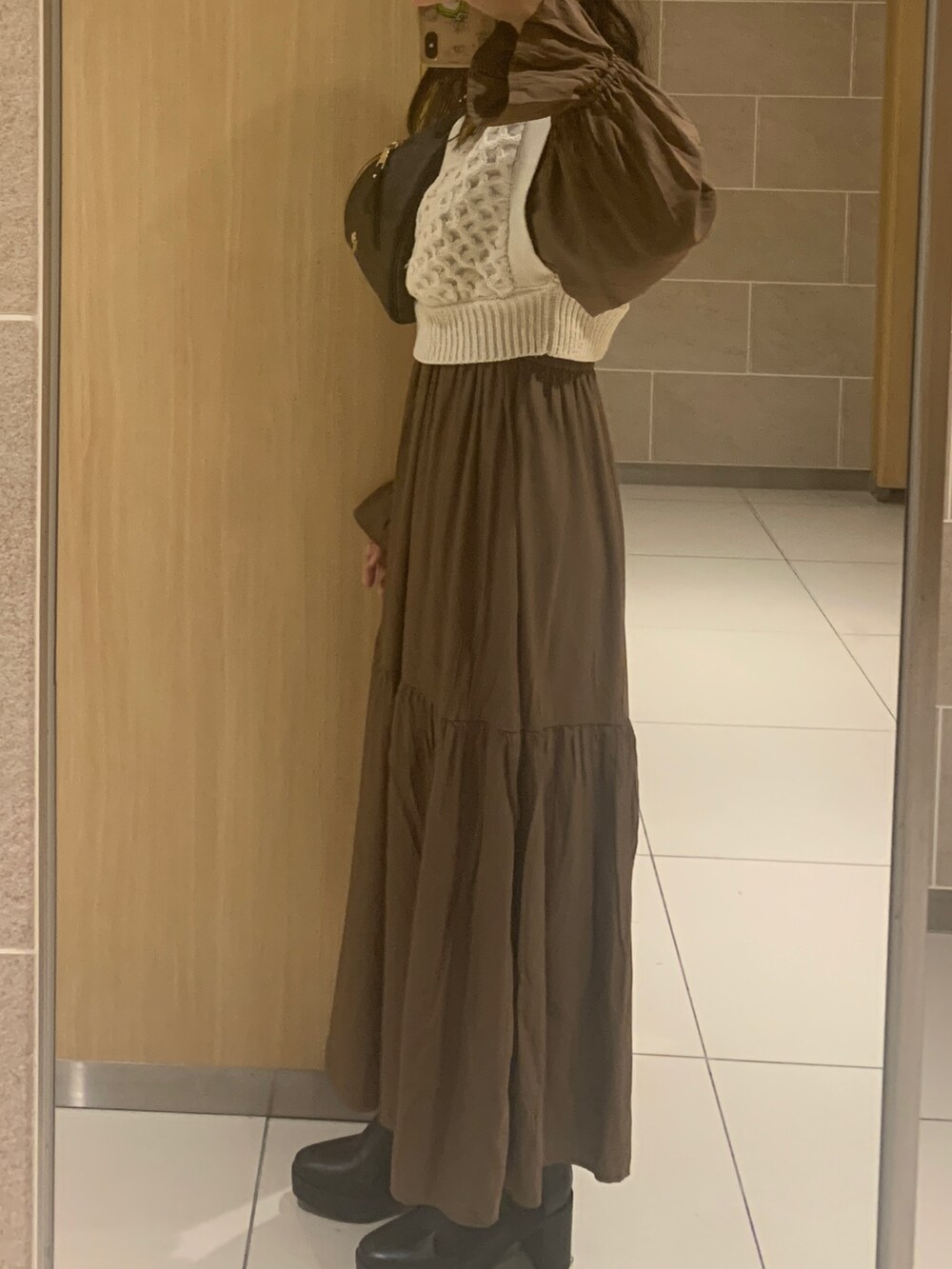 ブラウン系のワンピース、ブラウン系のボディバッグ/ウエストポーチ、ブラック系のブーツを着用したレディースの秋コーディネートの2枚目の写真