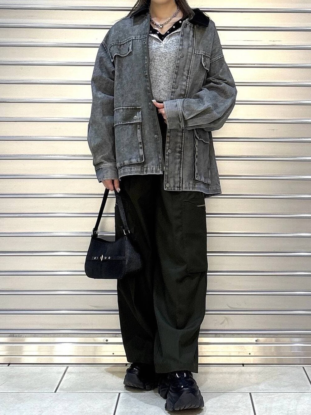 ブラック系のスニーカー、グリーン系のスラックス、ブラック系のハンドバッグを着用したレディースの春コーディネートの4枚目の写真