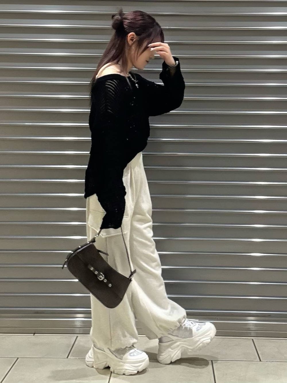 ホワイト系のスニーカー、ホワイト系のキャミソール、ブラウン系のハンドバッグを着用したレディースの春コーディネートの2枚目の写真