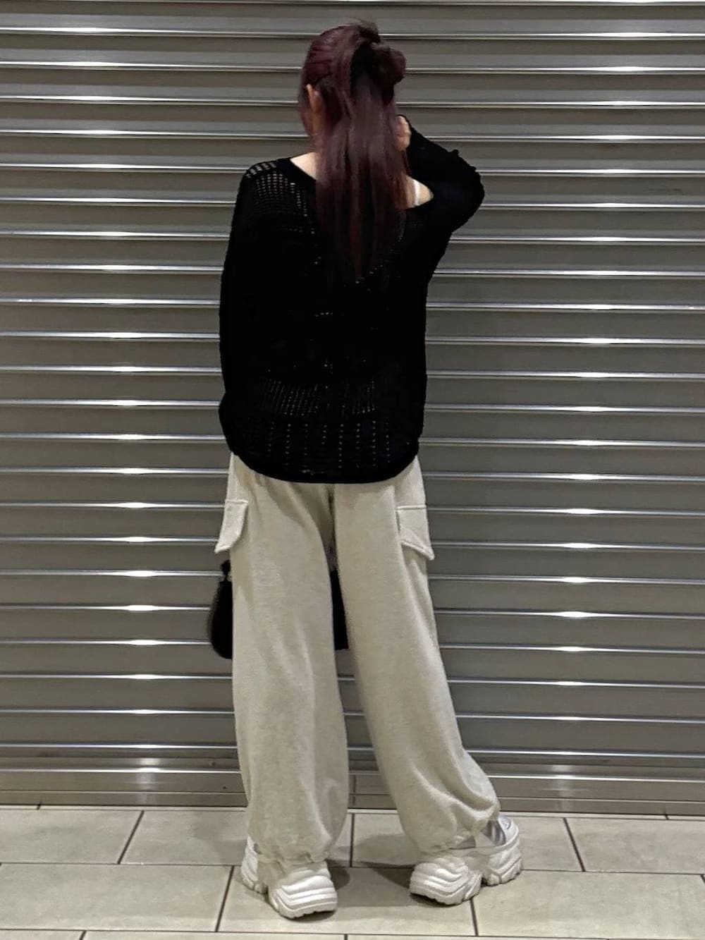 ホワイト系のスニーカー、ホワイト系のキャミソール、ブラウン系のハンドバッグを着用したレディースの春コーディネートの3枚目の写真