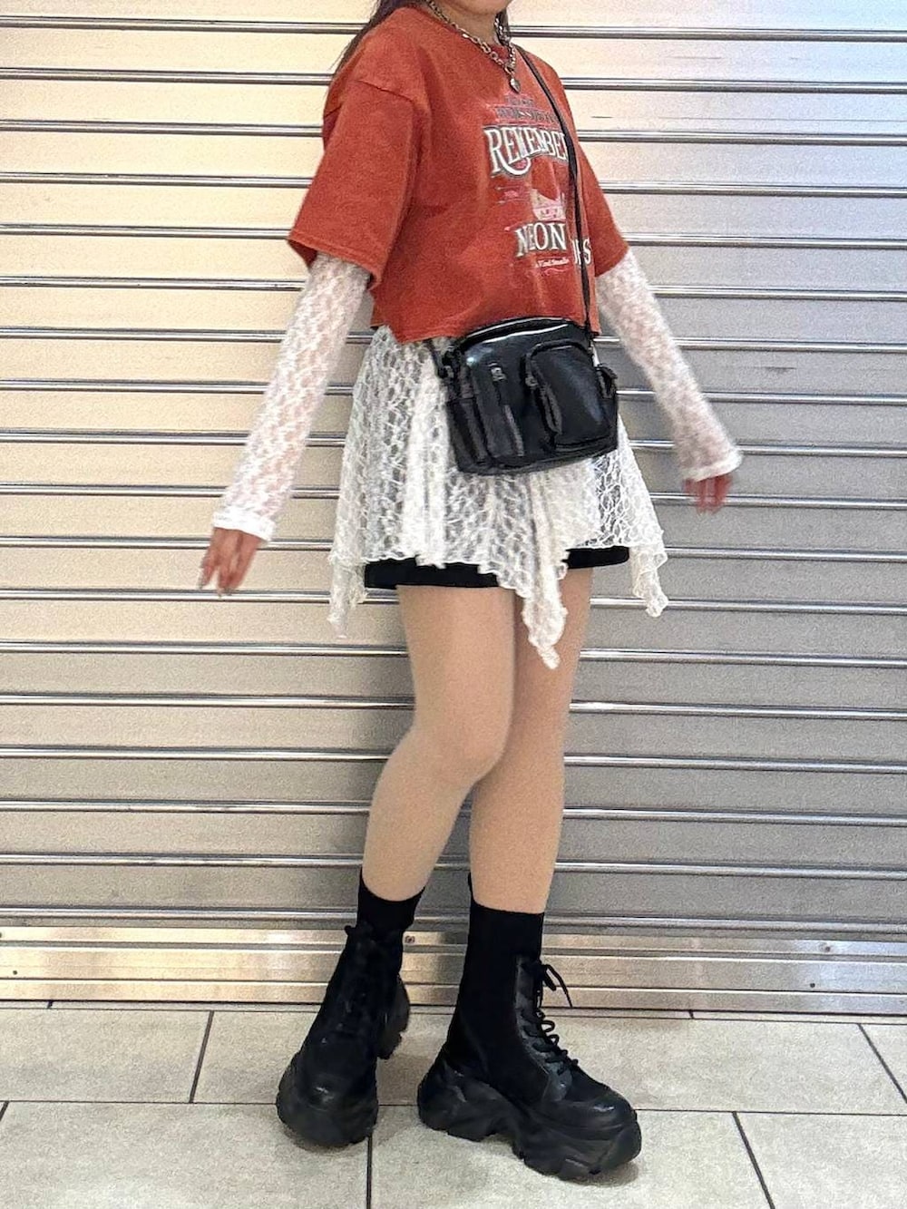 ブラック系のブーツ、ホワイト系のチュニック、ブラック系のショルダーバッグを着用したレディースの春コーディネートの4枚目の写真