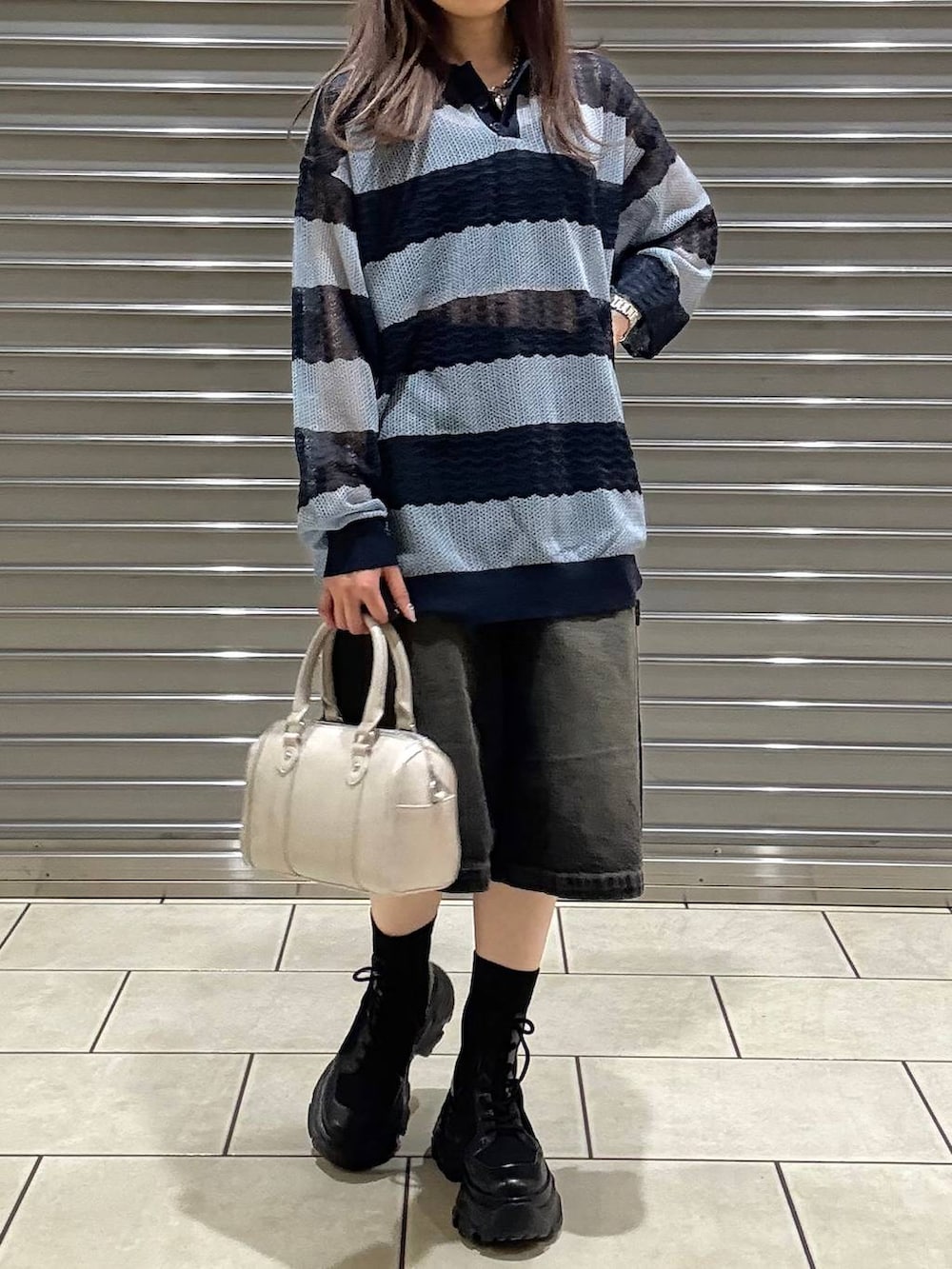 ブラック系のブーツ、ブラック系のキャミソール、ホワイト系のボストンバッグを着用したレディースの春コーディネートの4枚目の写真