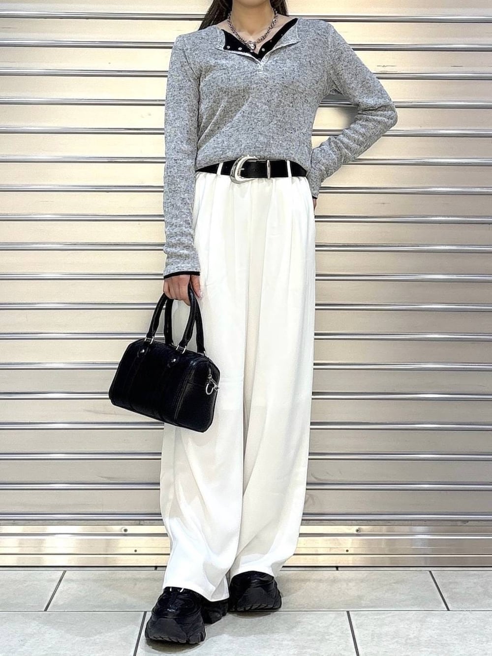 ブラック系のスニーカー、ブラック系のボストンバッグ、ブラック系のTシャツ/カットソーを着用したレディースの冬コーディネートの4枚目の写真