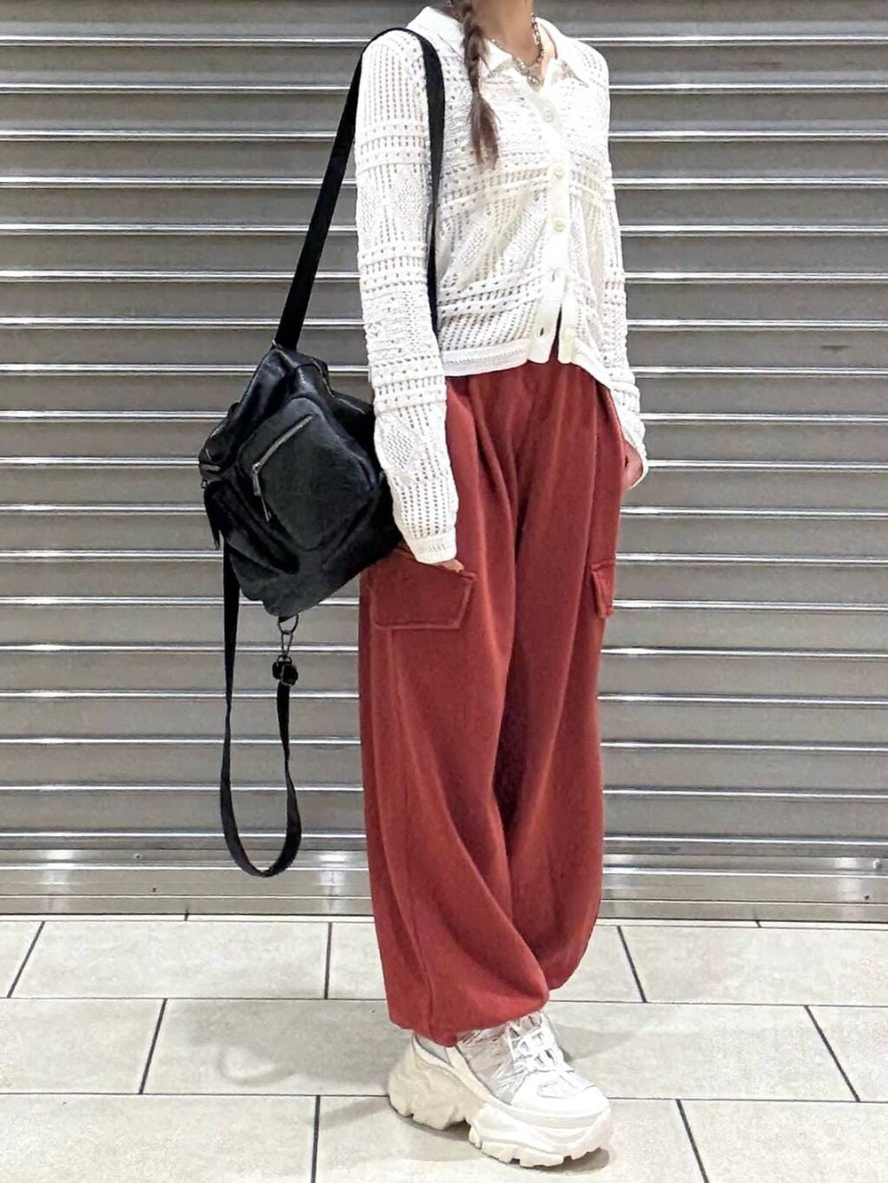 ホワイト系のスニーカー、ホワイト系のキャミソール、ブラック系のショルダーバッグを着用したレディースの春コーディネートの4枚目の写真