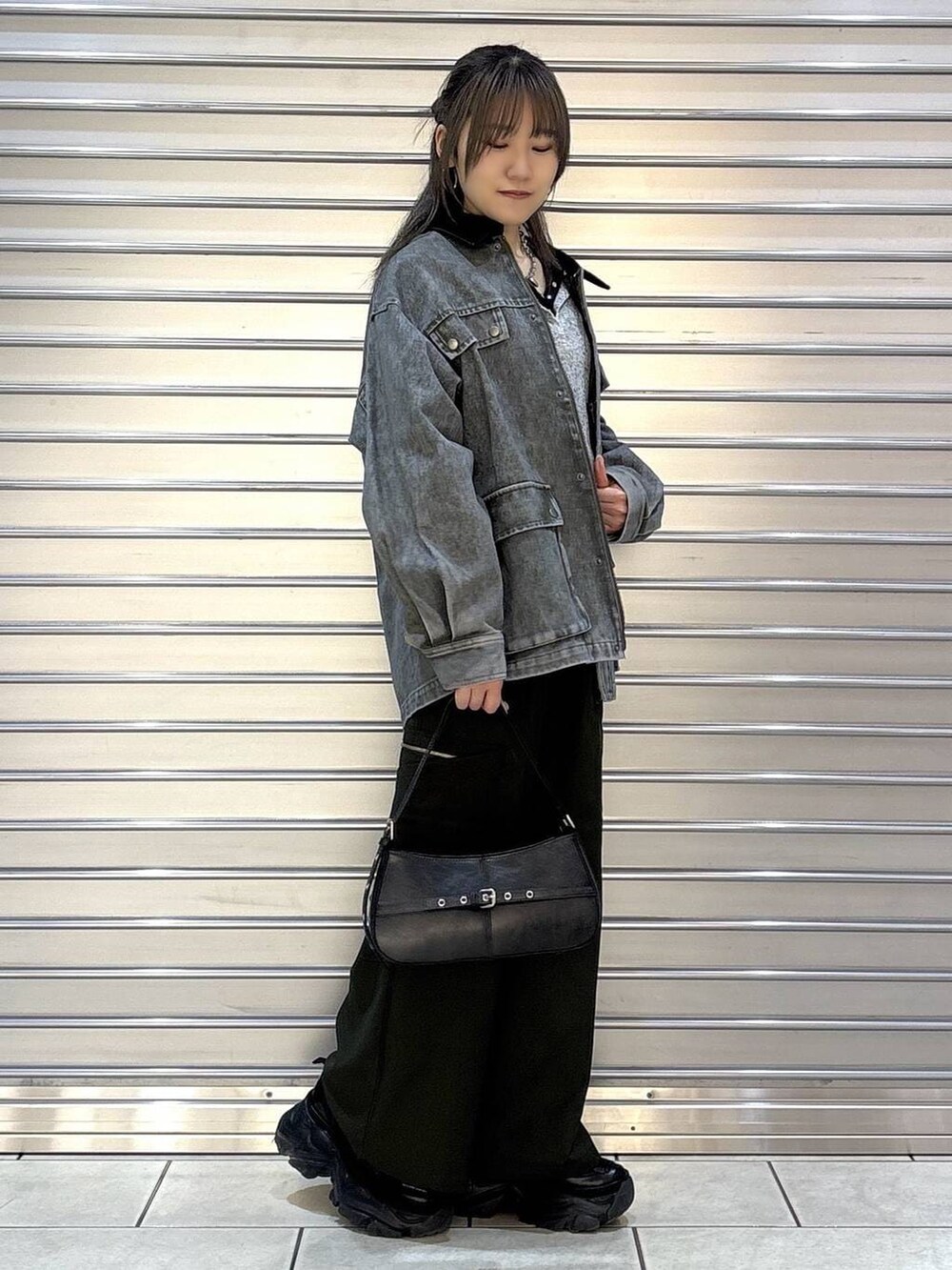 ブラック系のスニーカー、グリーン系のスラックス、ブラック系のハンドバッグを着用したレディースの春コーディネートの2枚目の写真