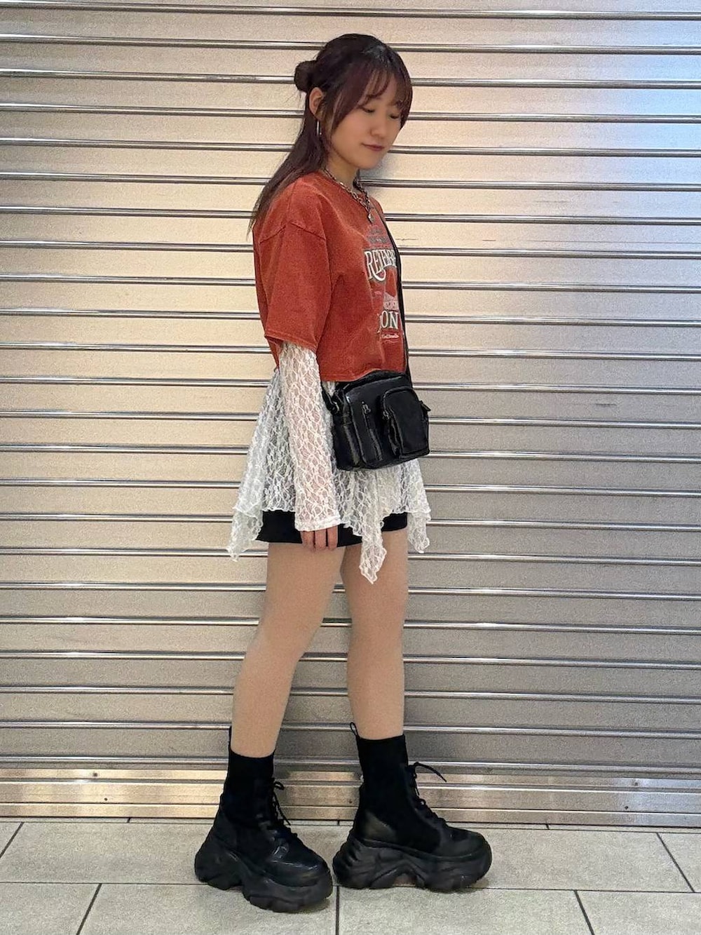 ブラック系のブーツ、ホワイト系のチュニック、ブラック系のショルダーバッグを着用したレディースの春コーディネートの2枚目の写真