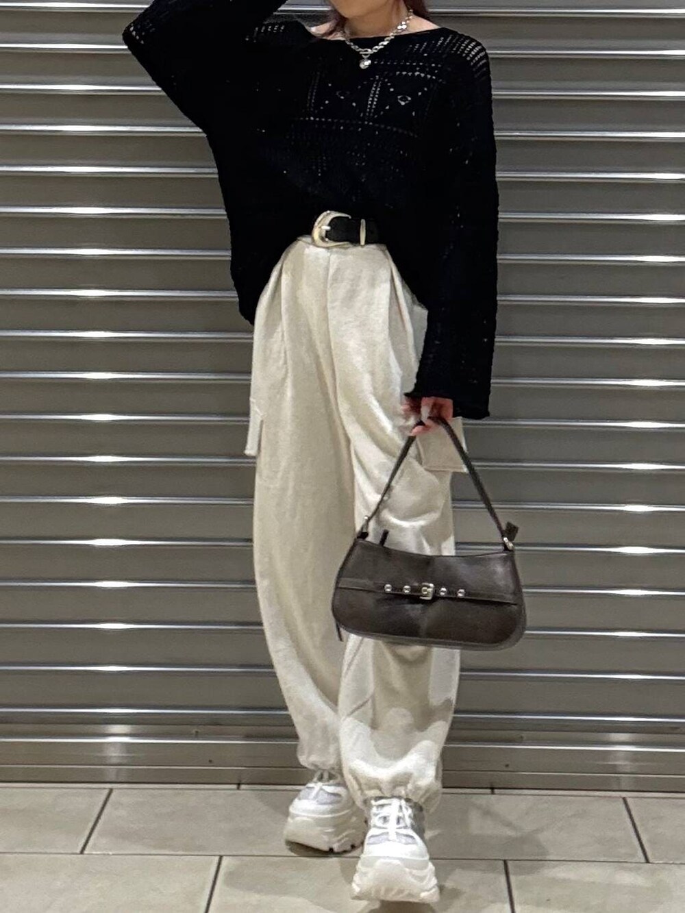ホワイト系のスニーカー、ホワイト系のキャミソール、ブラウン系のハンドバッグを着用したレディースの春コーディネートの4枚目の写真