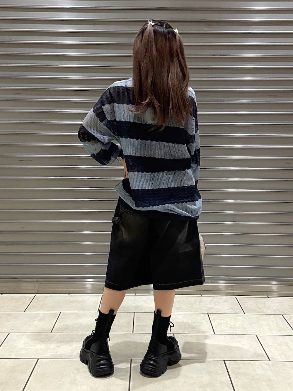 ブラック系のブーツ、ブラック系のキャミソール、ホワイト系のボストンバッグを着用したレディースの春コーディネートの3枚目の写真