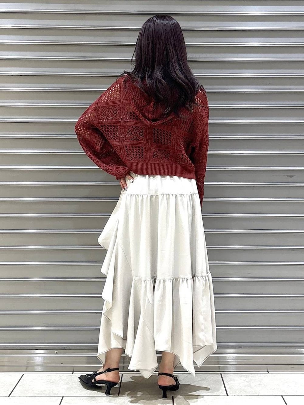 ブラック系のキャミソール、ベージュ系のスカート、ブラック系のボストンバッグを着用したレディースの春コーディネートの3枚目の写真