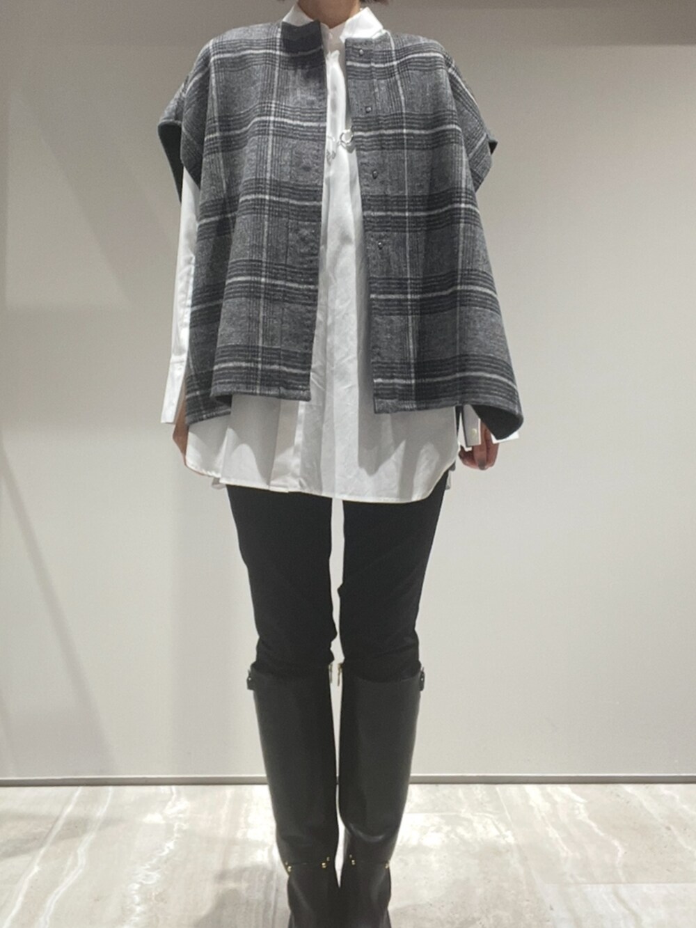 グリーン系のショルダーバッグ、その他のポンチョ、ホワイト系のシャツ/ブラウスを着用したレディースの秋コーディネートの2枚目の写真