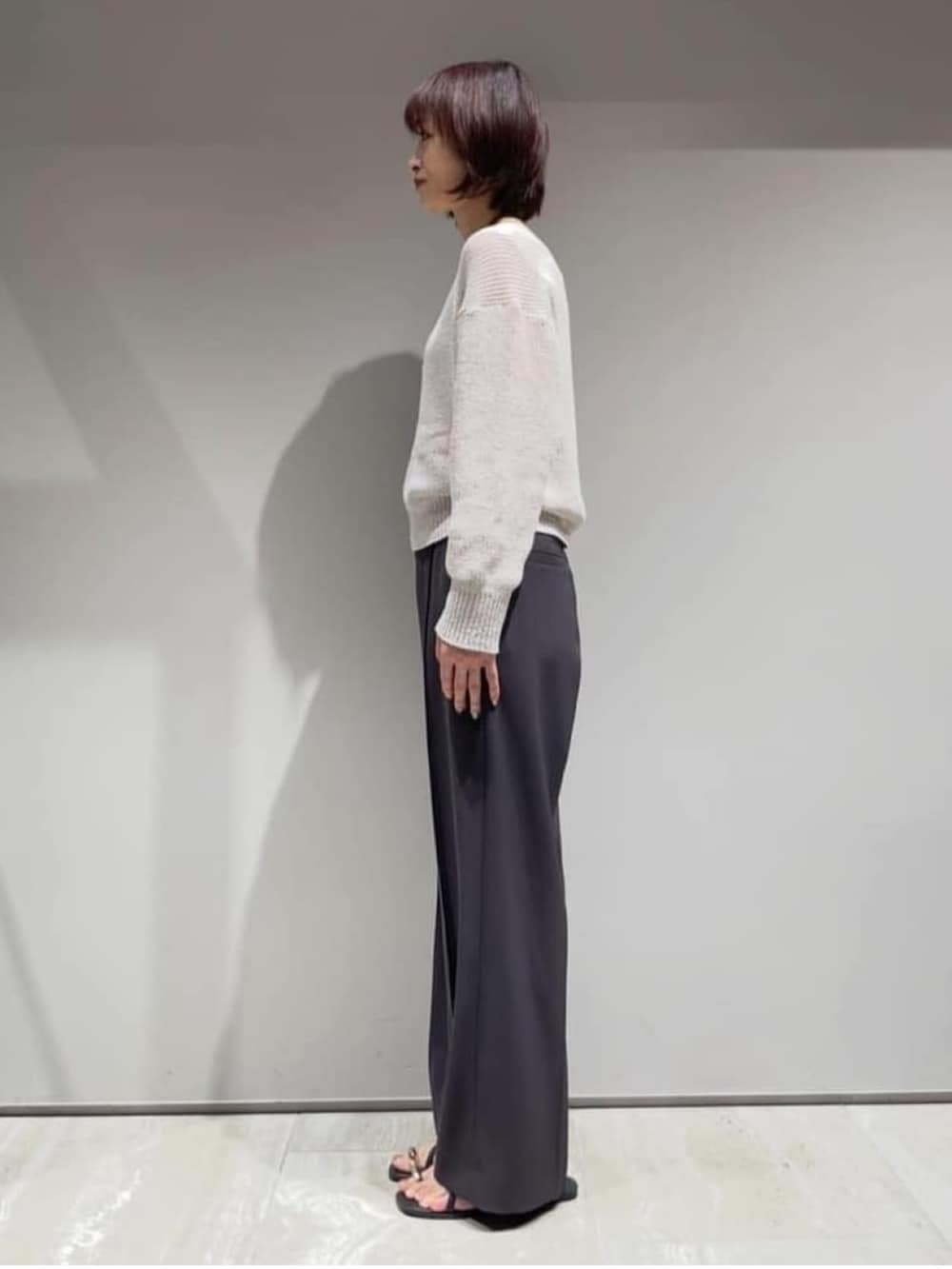 グレー系のその他パンツ、ベージュ系のニット/セーター、ホワイト系のタンクトップを着用したレディースの春コーディネートの5枚目の写真