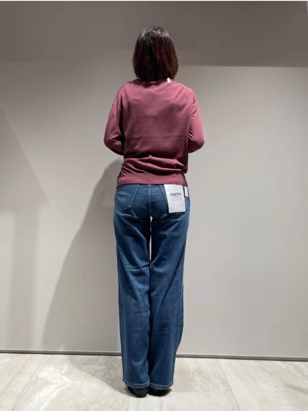 ブルー系のデニムパンツ、レッド系のカーディガン/ボレロ、ゴールド系のネックレスを着用したレディースの秋コーディネートの7枚目の写真